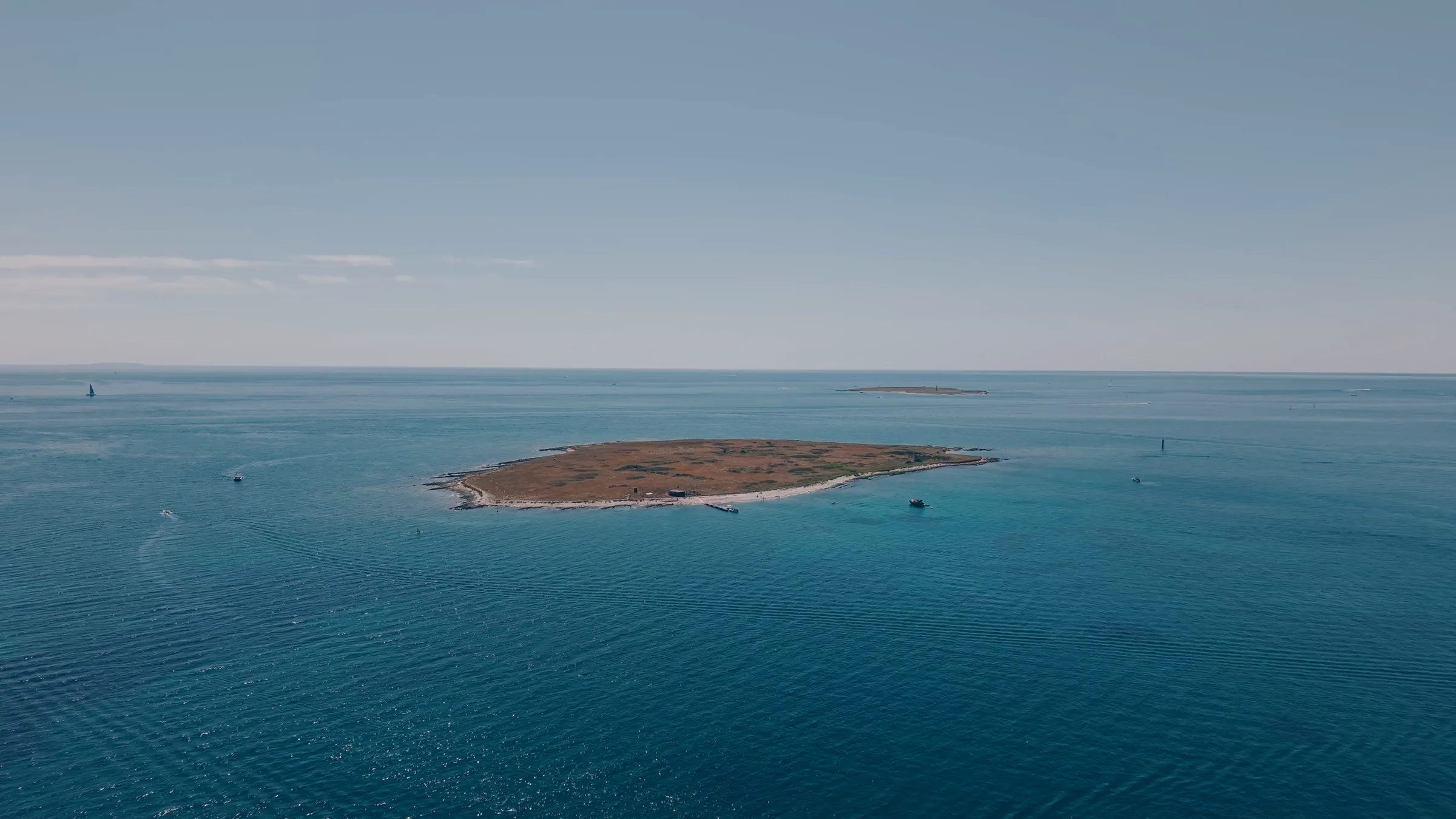 Calm turquoise water beside a rocky coastline